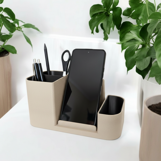 Beige desk organizer with office supplies on a white surface with plants in the background