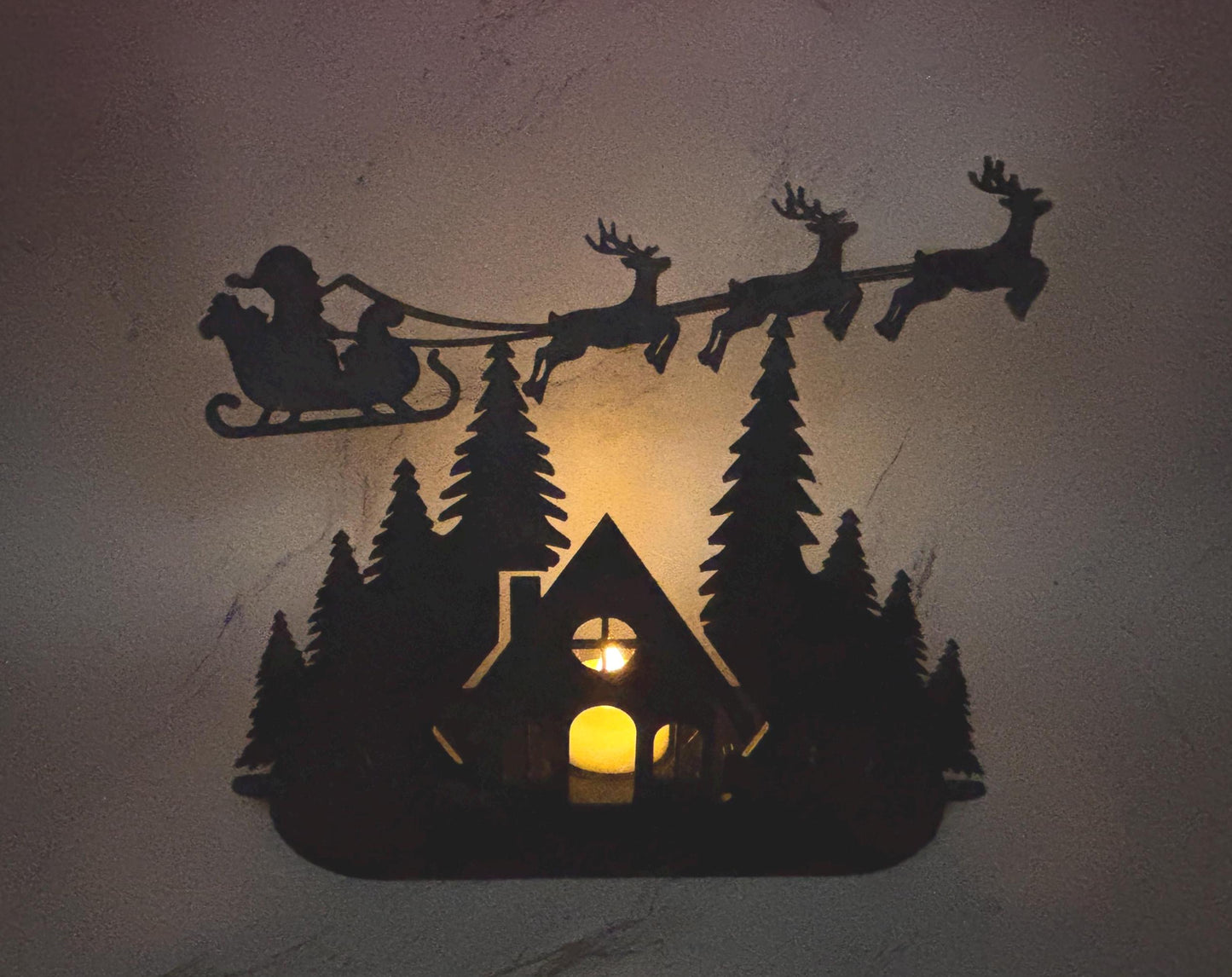 Christmas Tealight Display | Santa and his Reindeer Flying Over Cozy Woodland House