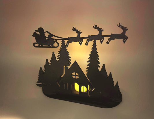Christmas Tealight Display | Santa and his Reindeer Flying Over Cozy Woodland House
